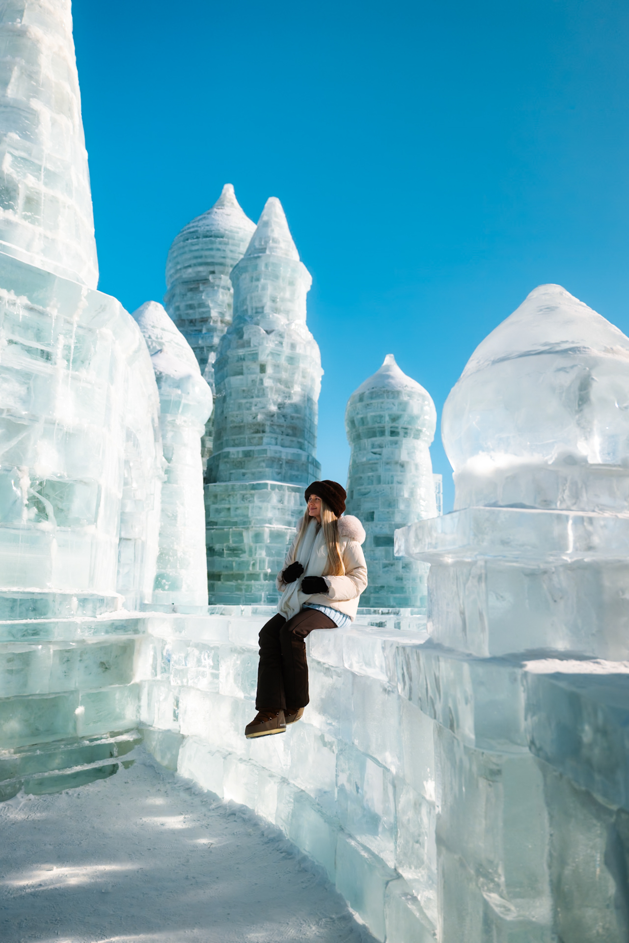 Woman exploring the ice sculptures at Harbin Ice and Snow World in winter, Harbin, China.