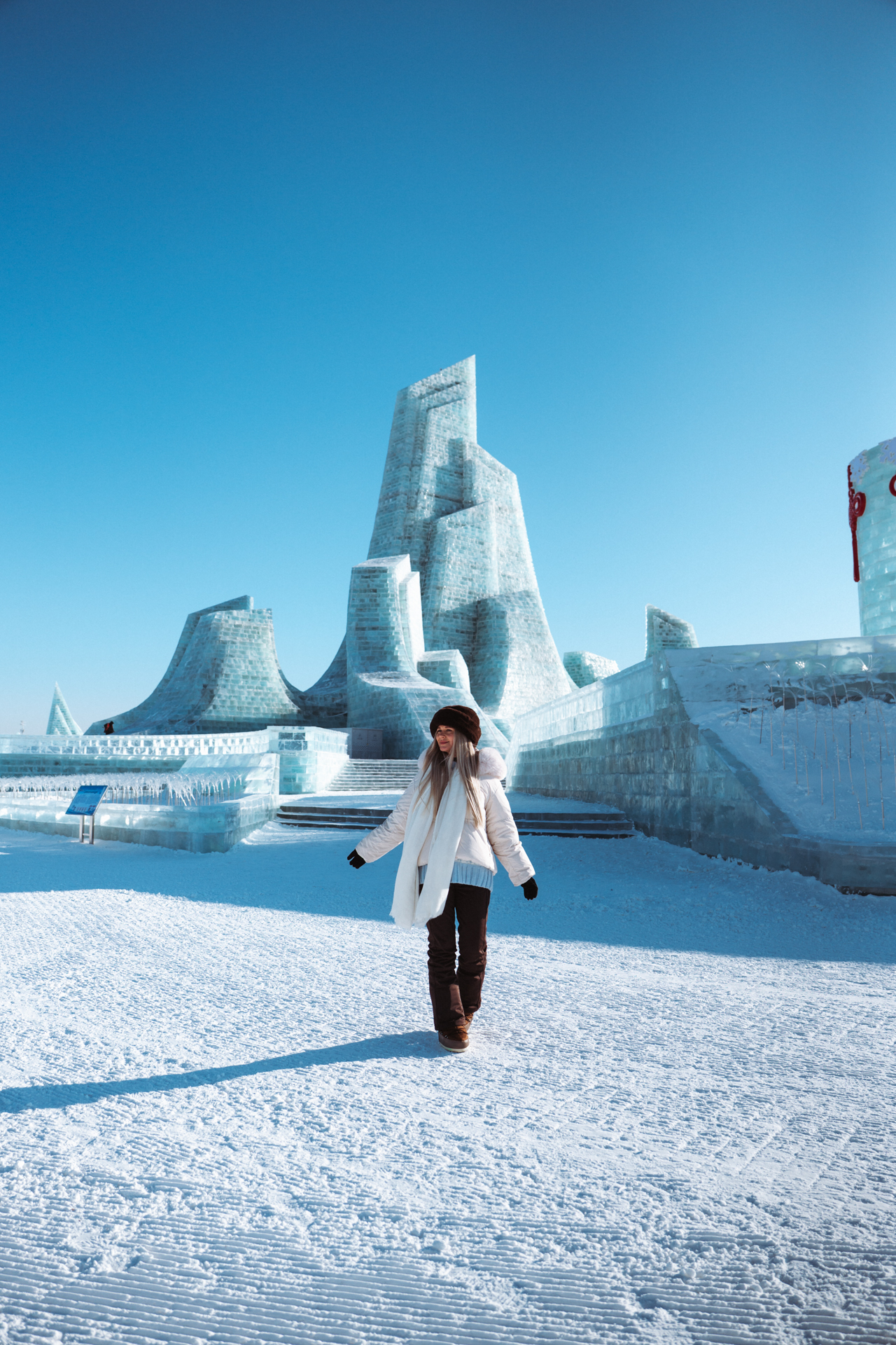 Woman exploring the ice sculptures at Harbin Ice and Snow World in winter, Harbin, China.