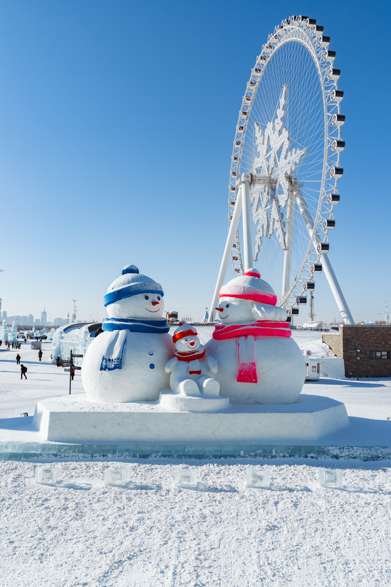 Snowman family with the giant Ferris wheel at Harbin Ice and Snow World, China.