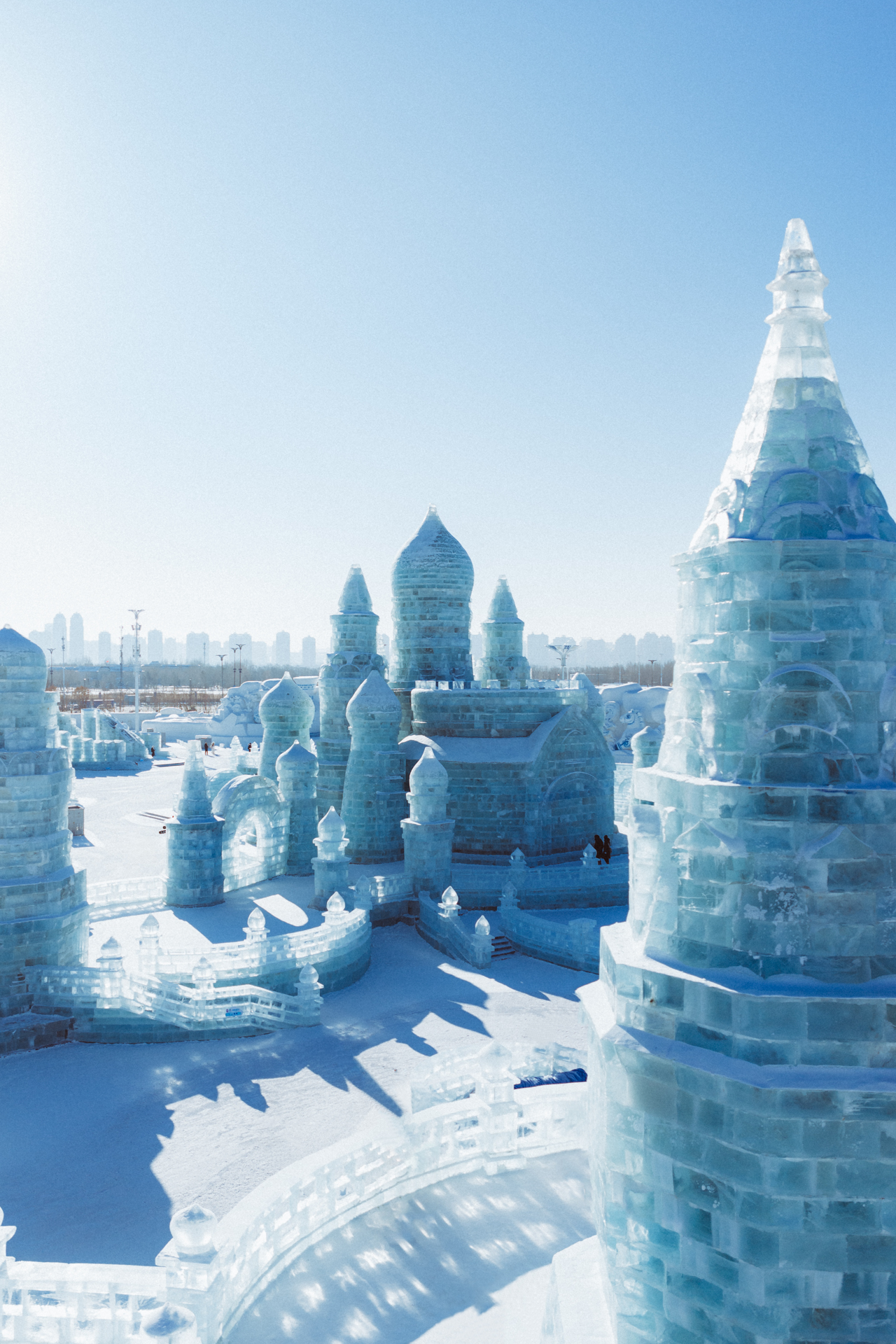 Ice castle structures at Harbin Ice and Snow World under a clear blue winter sky.