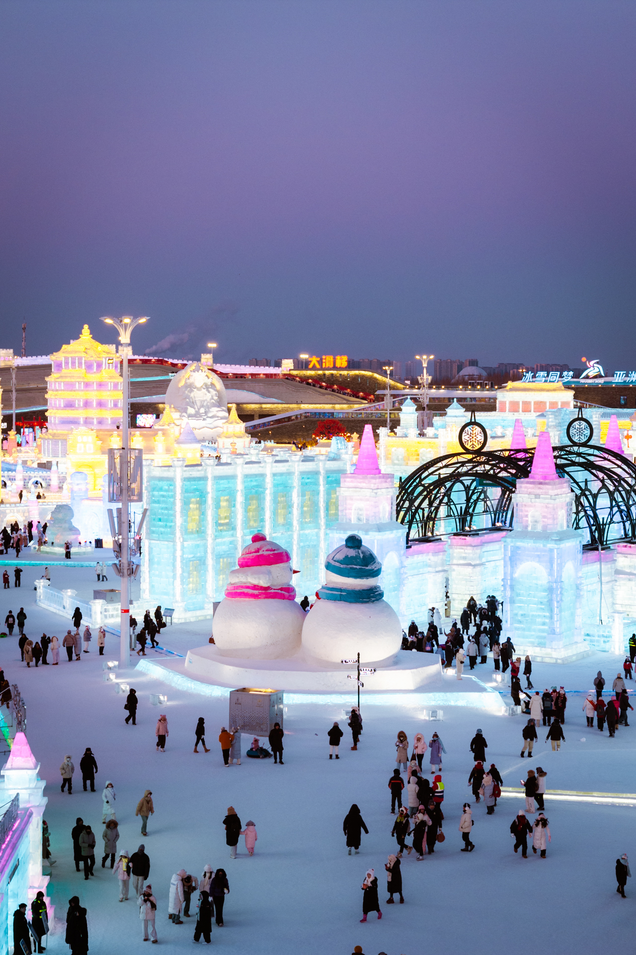 Colorful illuminated ice buildings and snowmen at Harbin Ice and Snow World.