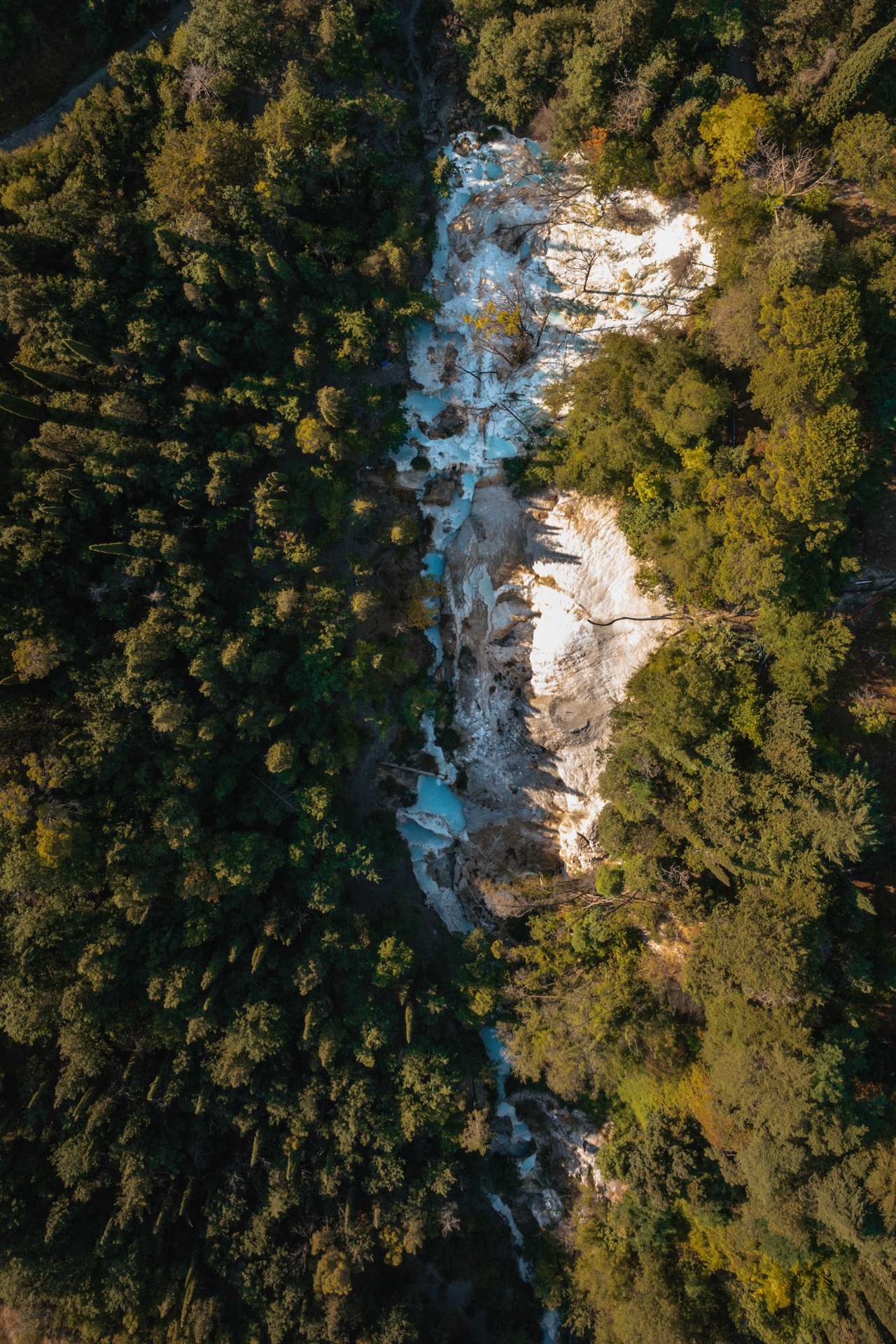 Aerial view of Bagni San Filippo hot springs surrounded by forest
