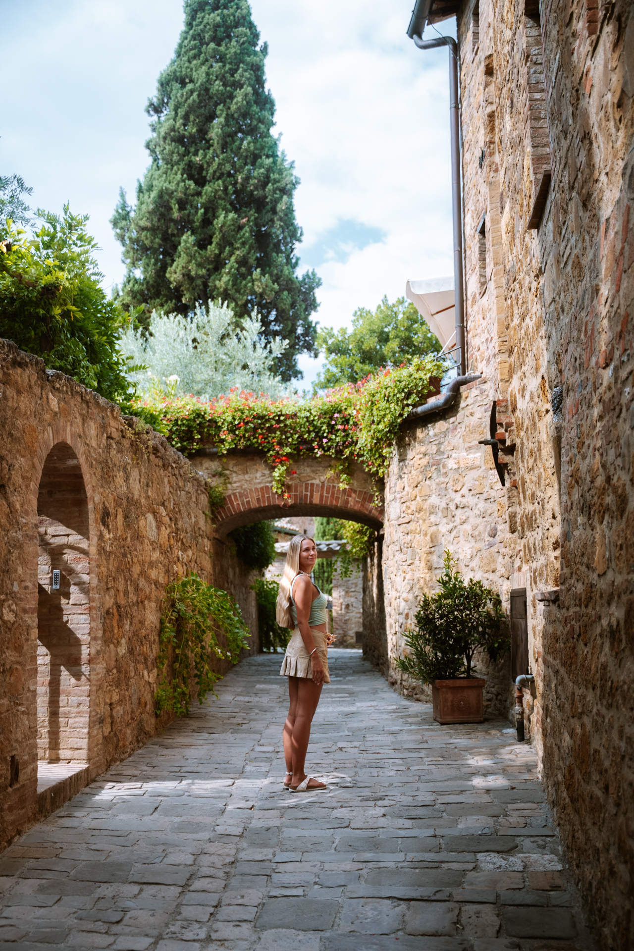 Walking through a charming stone street in San Quirico d’Orcia, Tuscany