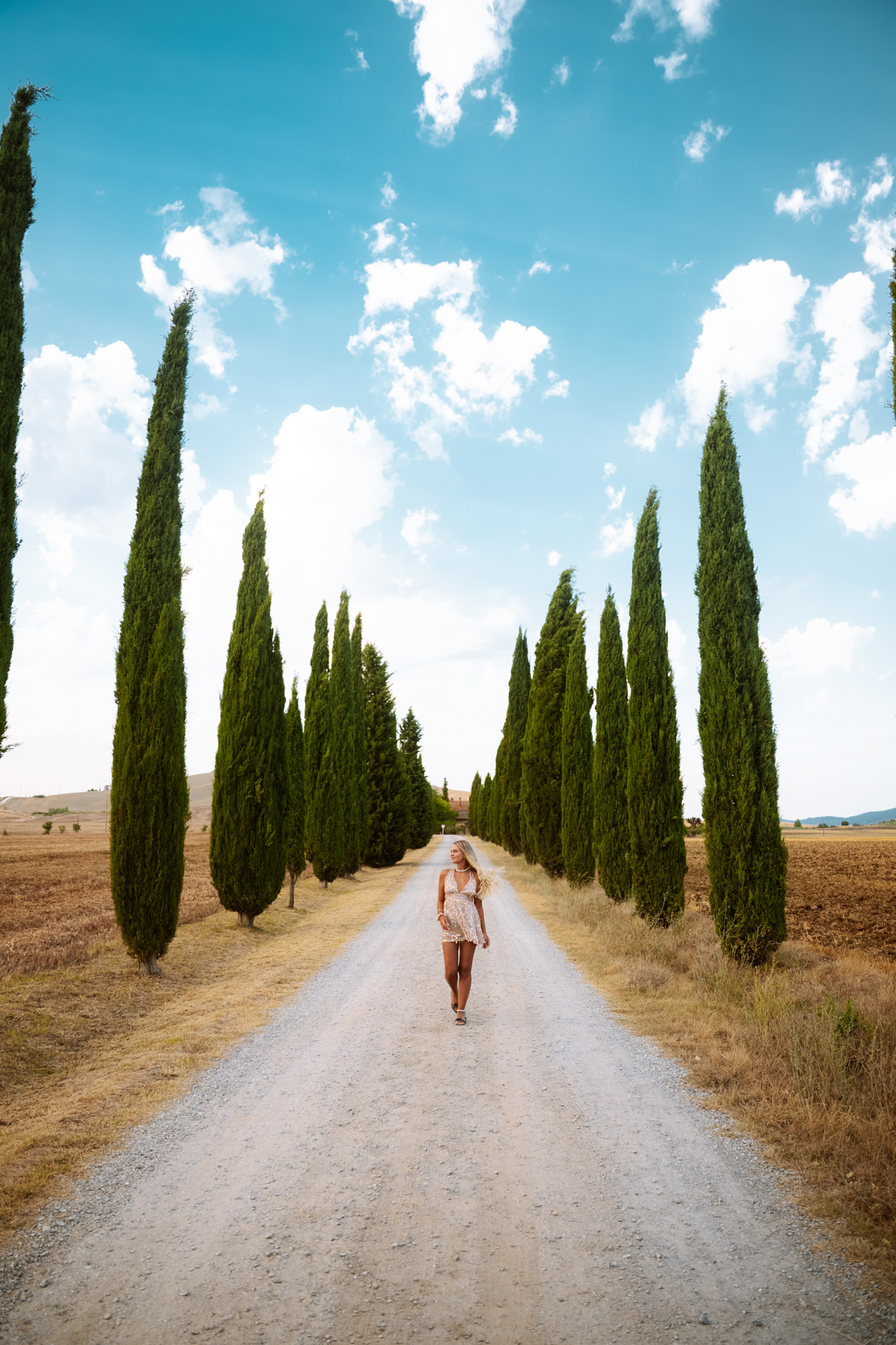 Walking along a cypress-lined road in the Tuscan countryside in Italy