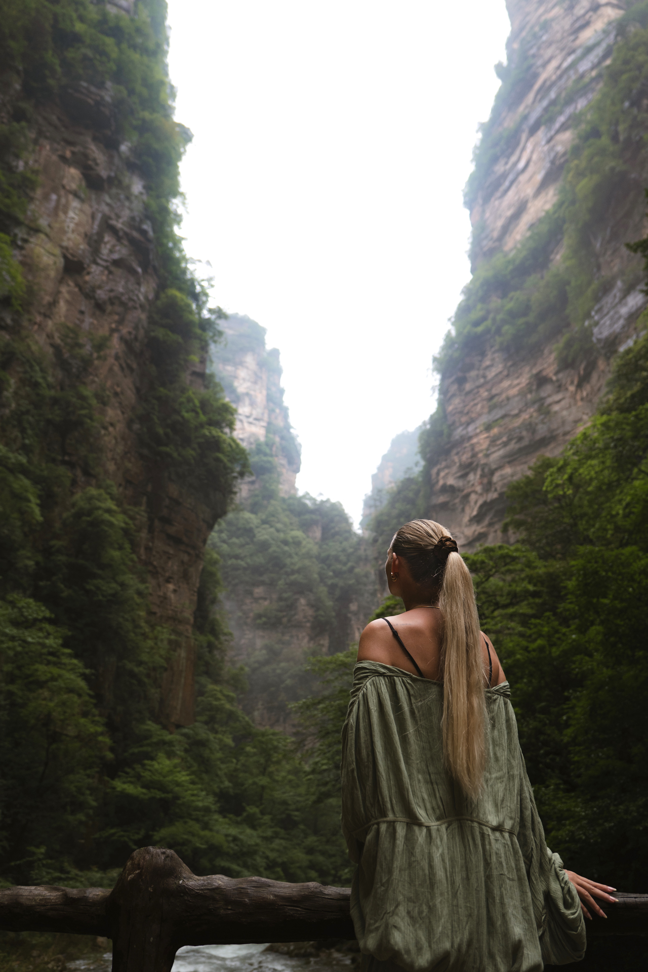 Woman overlooking towering cliffs in Zhangjiajie National Forest Park, China.
