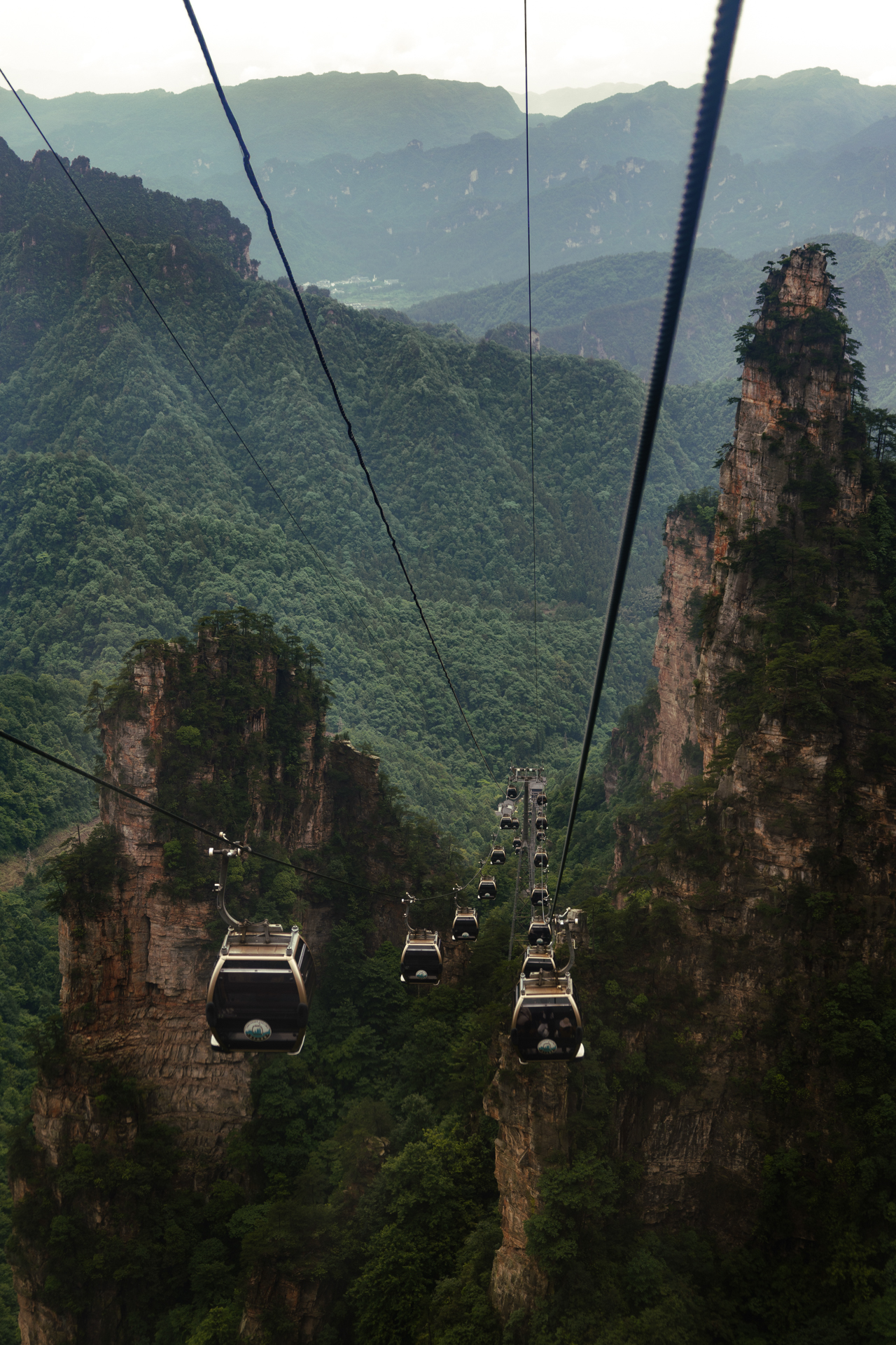 Cable cars passing between towering sandstone pillars in Zhangjiajie National Forest