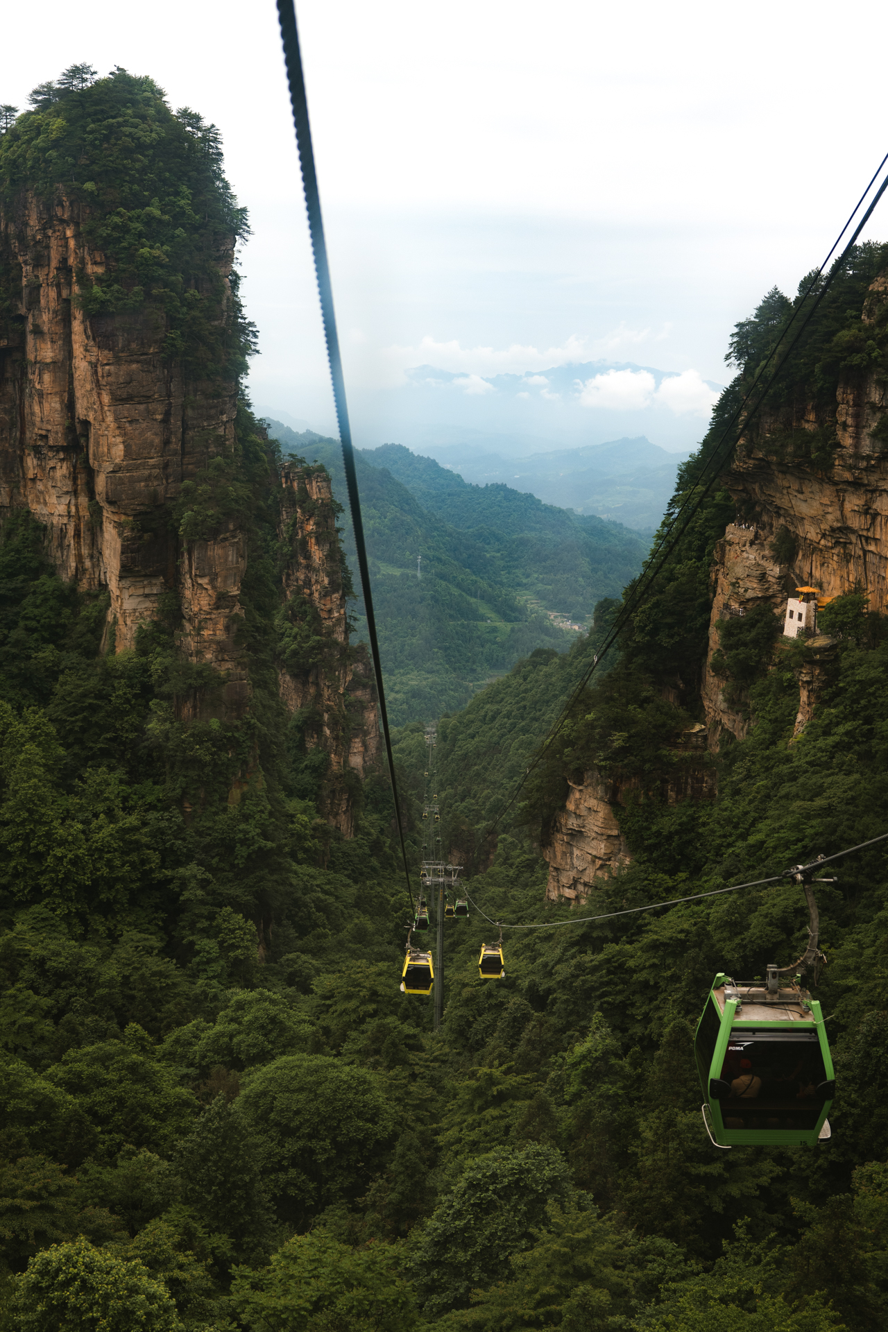 Cable cars crossing a deep mountain valley in Zhangjiajie, China.